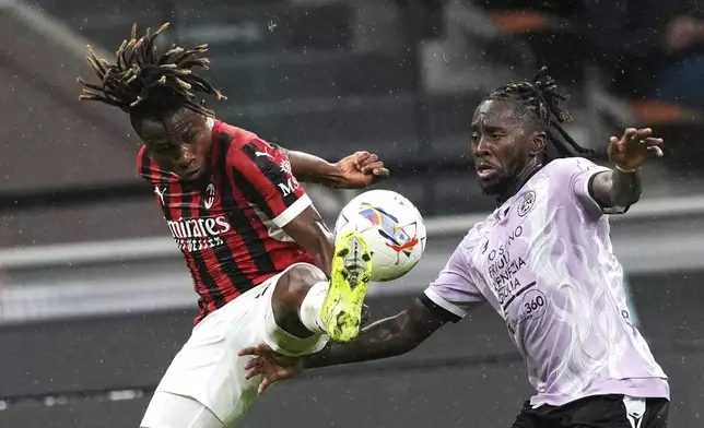 AC Milan's Samuel Chukwueze, left, and Udinese's Jordan Zemura challenge for the ball during the Serie A soccer match between AC Milan and Udinese at the San Siro Stadium, in Milan, Italy, Saturday, Oct. 19, 2024. (AP Photo/Antonio Calanni)