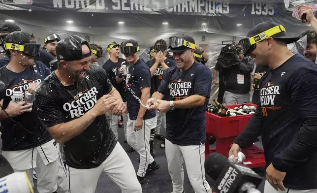 The Detroit Tigers celebrate their AL wild card berth after the ninth inning of a baseball game against the Chicago White Sox, Friday, Sept. 27, 2024, in Detroit. (AP Photo/Carlos Osorio)