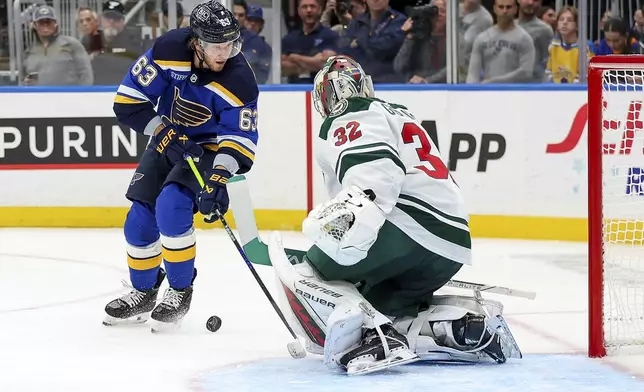 Minnesota Wild goaltender Filip Gustavsson (32) defends against St. Louis Blues' Jake Neighbours (63) during the second period of an NHL hockey game Tuesday, October 15, 2024, in St. Louis. (AP Photo/Scott Kane)