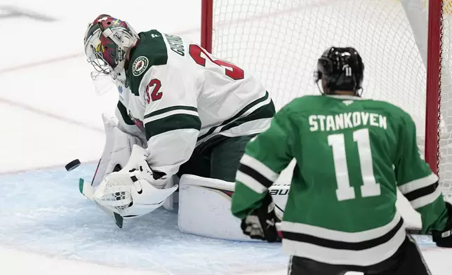 Minnesota Wild goaltender Filip Gustavsson (32) reaches out to glove a shot under pressure from Dallas Stars center Logan Stankoven (11) in the second period of a preseason NHL hockey game Wednesday, Sept. 25, 2024, in Dallas. (AP Photo/Tony Gutierrez)