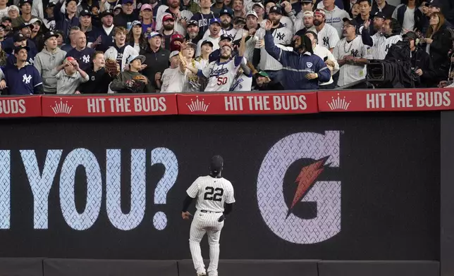 New York Yankees right fielder Juan Soto watches a fans reach to catch a home run by Los Angeles Dodgers' Will Smith during the fifth inning in Game 4 of the baseball World Series, Tuesday, Oct. 29, 2024, in New York. (AP Photo/Godofredo A. Vásquez)