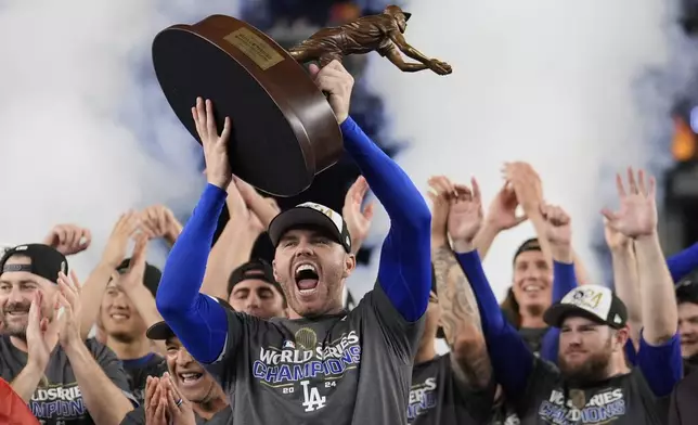 Los Angeles Dodgers' Freddie Freeman celebrates with the MVP trophy after their win against the New York Yankees in Game 5 to win the baseball World Series, Thursday, Oct. 31, 2024, in New York. (AP Photo/Ashley Landis)