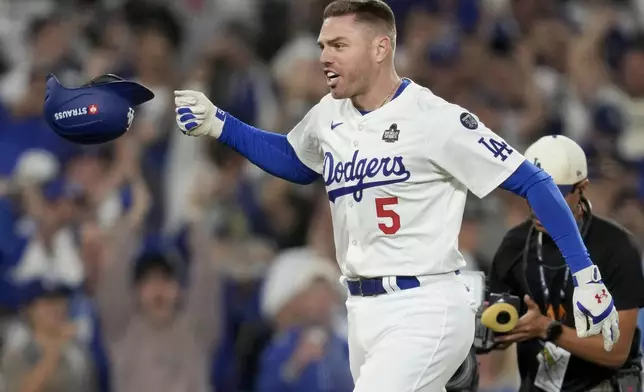 Los Angeles Dodgers' Freddie Freeman celebrates his walk-off grand slam home run against the New York Yankees during the 10th inning in Game 1 of the baseball World Series, Friday, Oct. 25, 2024, in Los Angeles. (AP Photo/Ashley Landis)