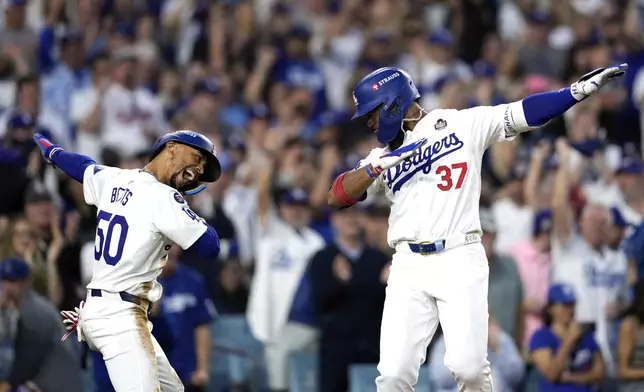 Los Angeles Dodgers' Teoscar Hernández (37) and Mookie Betts (50) celebrate after both scored on Hernádez's home run against the New York Yankees during the third inning in Game 2 of the baseball World Series, Saturday, Oct. 26, 2024, in Los Angeles. (AP Photo/Godofredo A. Vásquez)