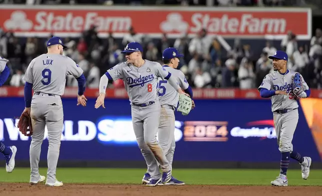 Los Angeles Dodgers' Gavin Lux (9), Kiké Hernández (8), Tommy Edman (25) and Mookie Betts (50) celebrate after Game 3 of the baseball World Series against the New York Yankees, Monday, Oct. 28, 2024, in New York. The Dodgers won 4-2. (AP Photo/Godofredo A. Vásquez)