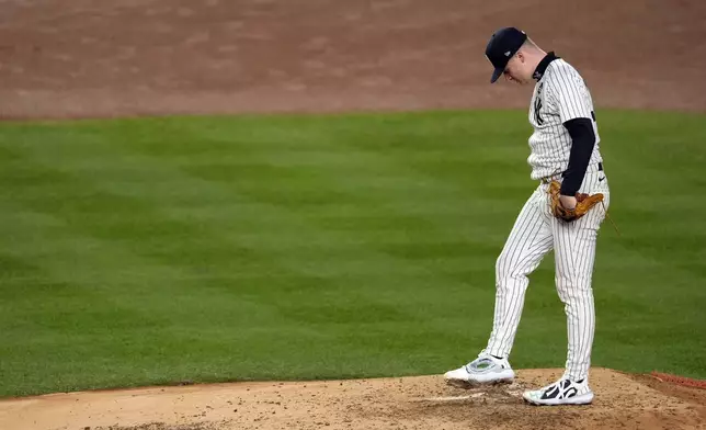 New York Yankees starting pitcher Clarke Schmidt waits for manager Aaron Boone to make his way to the mound to pull him during the third inning in Game 3 of the baseball World Series against the Los Angeles Dodgers, Monday, Oct. 28, 2024, in New York. (AP Photo/Seth Wenig)