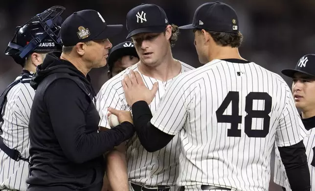 New York Yankees starting pitcher Gerrit Cole, center, is pulled by manager Aaron Boone, left, as first baseman Anthony Rizzo (48) puts his hand on the Cole's shoulder during the seventh inning in Game 5 of the baseball World Series against the Los Angeles Dodgers, Wednesday, Oct. 30, 2024, in New York. (AP Photo/Godofredo A. Vásquez)