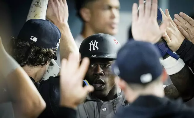 New York Yankees' Jazz Chisholm Jr. celebrates in the dugout after scoring on a fielders choice by Anthony Volpe against the Los Angeles Dodgers during the 10th inning in Game 1 of the baseball World Series, Friday, Oct. 25, 2024, in Los Angeles. (AP Photo/Ashley Landis)