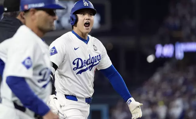 Los Angeles Dodgers' Shohei Ohtani reacts after advancing to third on a fielding error by New York Yankees second baseman Gleyber Torres during the eighth inning in Game 1 of the baseball World Series, Friday, Oct. 25, 2024, in Los Angeles. (AP Photo/Godofredo A. Vásquez)