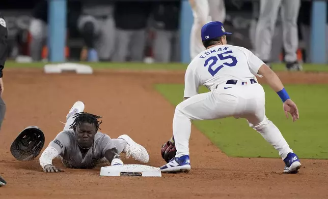 New York Yankees' Jazz Chisholm Jr. steals second base next to Los Angeles Dodgers shortstop Tommy Edman during the 10th inning in Game 1 of the baseball World Series, Friday, Oct. 25, 2024, in Los Angeles. (AP Photo/Mark J. Terrill)