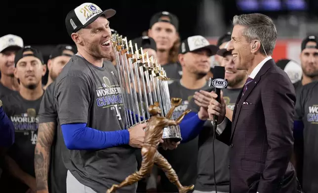 Los Angeles Dodgers' Freddie Freeman celebrates with the trophy after their win against the New York Yankees in Game 5 to win the baseball World Series, Thursday, Oct. 31, 2024, in New York. (AP Photo/Ashley Landis)