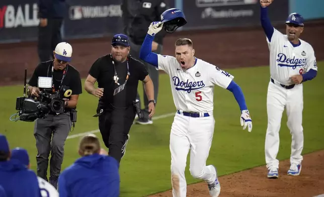 Los Angeles Dodgers' Freddie Freeman (5) celebrates after hitting a game-winning grand slam against the New York Yankees during the 10th inning in Game 1 of the baseball World Series, Friday, Oct. 25, 2024, in Los Angeles. The Dodgers won 6-3. (AP Photo/Julio Cortez)