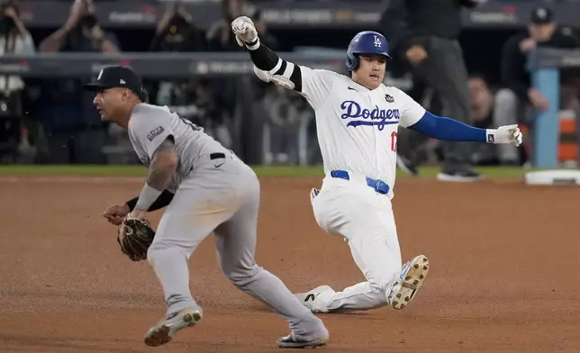 Los Angeles Dodgers' Shohei Ohtani slides into second base for a double past New York Yankees second baseman Gleyber Torres during the eighth inning in Game 1 of the baseball World Series, Friday, Oct. 25, 2024, in Los Angeles. (AP Photo/Mark J. Terrill)