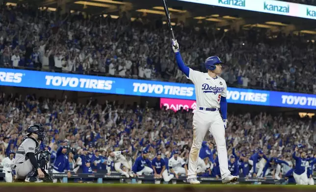 Los Angeles Dodgers' Freddie Freeman celebrates his walk-off grand slam home run against the New York Yankees during the 10th inning in Game 1 of the baseball World Series, Friday, Oct. 25, 2024, in Los Angeles. (AP Photo/Ashley Landis)