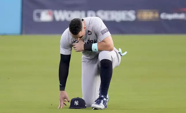 New York Yankees' Aaron Judge kneels in the outfield before Game 2 of the baseball World Series against the Los Angeles Dodgers, Saturday, Oct. 26, 2024, in Los Angeles. (AP Photo/Mark J. Terrill)