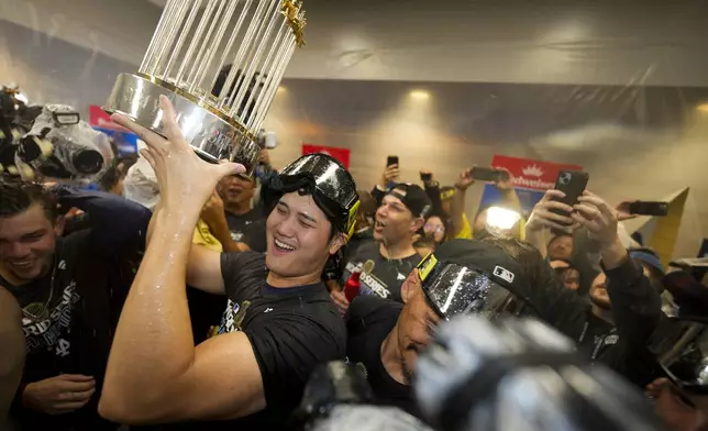 Los Angeles Dodgers' Shohei Ohtani celebrates in the locker room after their win against the New York Yankees in Game 5 to win the baseball World Series, Thursday, Oct. 31, 2024, in New York. (AP Photo/Ashley Landis)