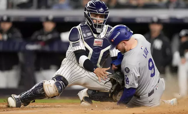 Los Angeles Dodgers' Gavin Lux scores past New York Yankees catcher Jose Trevino during the sixth inning in Game 3 of the baseball World Series, Monday, Oct. 28, 2024, in New York. (AP Photo/Ashley Landis)