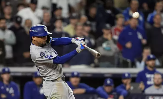 Los Angeles Dodgers' Mookie Betts hits a sacrifice fly against the New York Yankees during the eighth inning in Game 5 of the baseball World Series, Wednesday, Oct. 30, 2024, in New York. (AP Photo/Godofredo A. Vásquez)