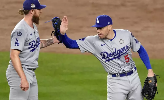 Los Angeles Dodgers' Freddie Freeman (5) and Michael Kopech celebrate after Game 3 of the baseball World Series against the New York Yankees, Monday, Oct. 28, 2024, in New York. The Dodgers won 4-2. (AP Photo/Seth Wenig)