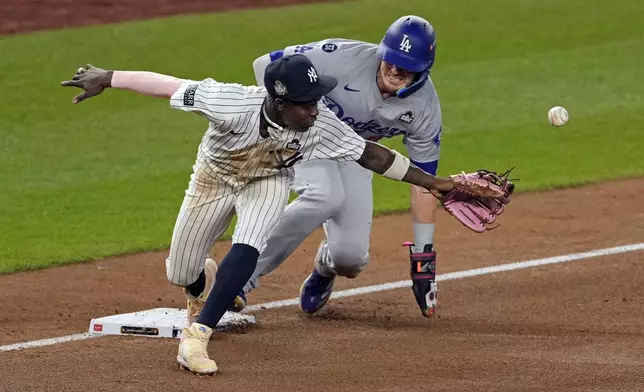 Los Angeles Dodgers' Kiké Hernández, right, is safe at third as New York Yankees third baseman Jazz Chisholm Jr. reaches for a throw from shortstop Anthony Volpe during the fifth inning in Game 5 of the baseball World Series, Wednesday, Oct. 30, 2024, in New York. Volpe was charged with a throwing error. (AP Photo/Seth Wenig)