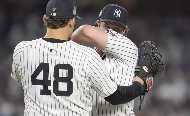 New York Yankees first baseman Anthony Rizzo (48) talks with starting pitcher Gerrit Cole during the fifth inning in Game 5 of the baseball World Series against the Los Angeles Dodgers, Wednesday, Oct. 30, 2024, in New York. (AP Photo/Godofredo A. Vásquez)