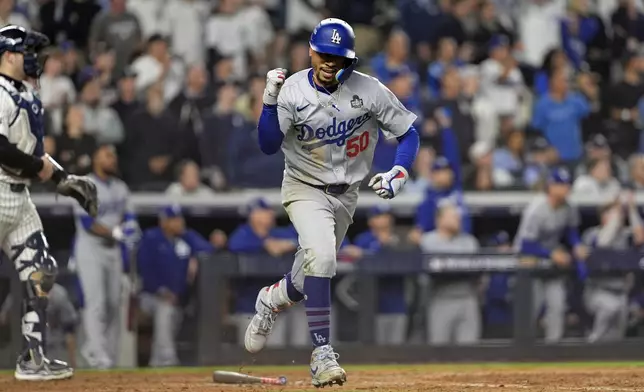 Los Angeles Dodgers' Mookie Betts (50) celebrates after hitting a sacrifice fly against the New York Yankees during the eighth inning in Game 5 of the baseball World Series, Wednesday, Oct. 30, 2024, in New York. (AP Photo/Godofredo A. Vásquez)