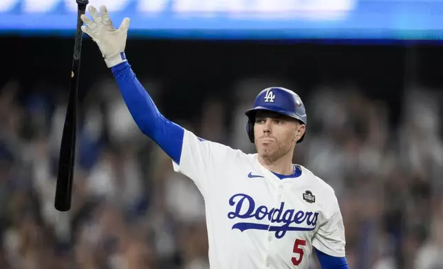 Los Angeles Dodgers' Freddie Freeman celebrates his walk-off grand slam home run against the New York Yankees during the 10th inning in Game 1 of the baseball World Series, Friday, Oct. 25, 2024, in Los Angeles. (AP Photo/Ashley Landis)