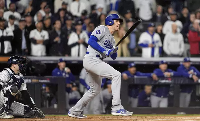 Los Angeles Dodgers' Freddie Freeman, right, watches his two-run home run against the New York Yankees during the first inning in Game 4 of the baseball World Series, Tuesday, Oct. 29, 2024, in New York. (AP Photo/Godofredo A. Vásquez)