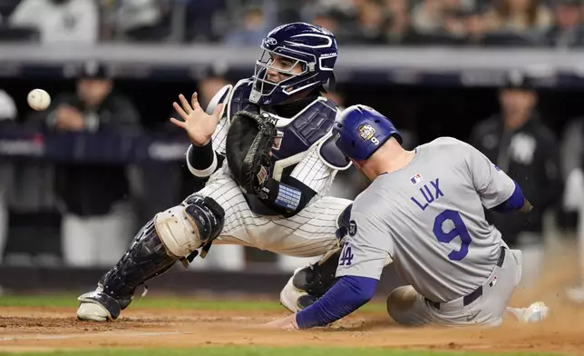 Los Angeles Dodgers' Gavin Lux scores past New York Yankees catcher Jose Trevino during the sixth inning in Game 3 of the baseball World Series, Monday, Oct. 28, 2024, in New York. (AP Photo/Ashley Landis)