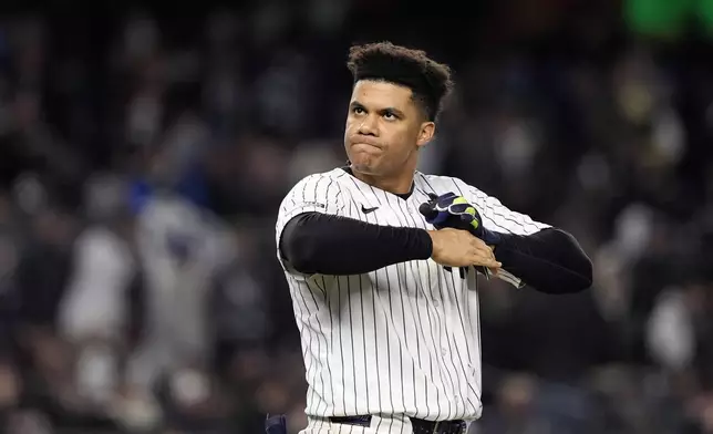 New York Yankees' Juan Soto takes off his batting gloves after grounding out against the New York Yankees to end the third inning in Game 3 of the baseball World Series, Monday, Oct. 28, 2024, in New York. (AP Photo/Godofredo A. Vásquez)