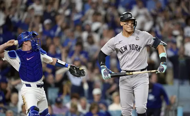 New York Yankees' Aaron Judge, right, reacts after striking out as Los Angeles Dodgers catcher Will Smith throws the ball around the infield during the sixth inning in Game 2 of the baseball World Series, Saturday, Oct. 26, 2024, in Los Angeles. (AP Photo/Godofredo A. Vásquez)