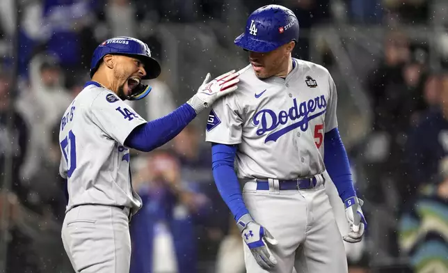 Los Angeles Dodgers' Freddie Freeman (5) and Mookie Betts celebrate after both scored on Freman's two-run home run against the New York Yankees during the first inning in Game 4 of the baseball World Series, Tuesday, Oct. 29, 2024, in New York. (AP Photo/Godofredo A. Vásquez)