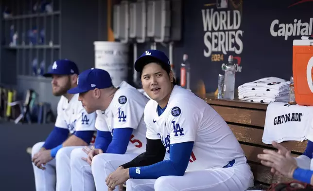 Los Angeles Dodgers' Shohei Ohtani waits in the dugout before Game 1 of the baseball World Series against the New York Yankees, Friday, Oct. 25, 2024, in Los Angeles. (AP Photo/Godofredo A. Vásquez)