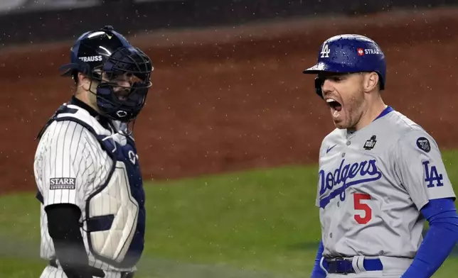 Los Angeles Dodgers' Freddie Freeman (5) celebrates after hitting a two-run home run as New York Yankees catcher Austin Wells watches during the first inning in Game 4 of the baseball World Series, Tuesday, Oct. 29, 2024, in New York. (AP Photo/Seth Wenig)