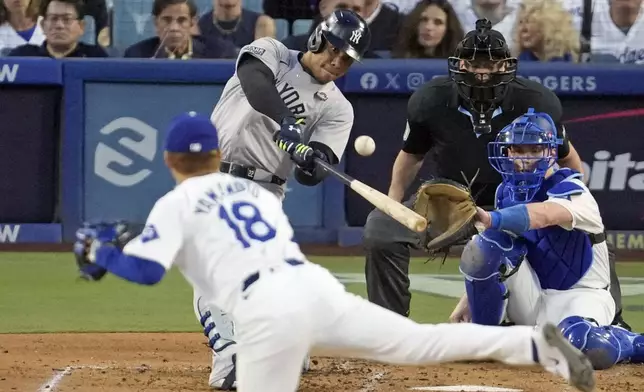 New York Yankees' Juan Soto, center, hits a home run off Los Angeles Dodgers starting pitcher Yoshinobu Yamamoto (18) during the third inning in Game 2 of the baseball World Series, Saturday, Oct. 26, 2024, in Los Angeles. (AP Photo/Julio Cortez)