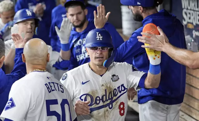 Los Angeles Dodgers' KikéHernández (8) celebrates in the dugout after scoring against the New York Yankees during the fifth inning in Game 1 of the baseball World Series, Friday, Oct. 25, 2024, in Los Angeles. (AP Photo/Godofredo A. Vásquez)