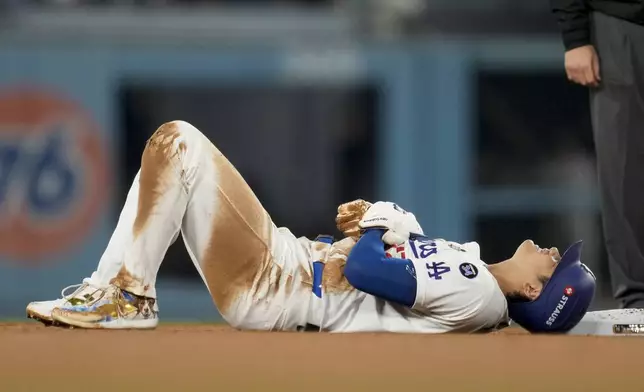 Los Angeles Dodgers' Shohei Ohtani is gets hurt sliding into second base during the seventh inning in Game 2 of the baseball World Series against the New York Yankees, Saturday, Oct. 26, 2024, in Los Angeles. (AP Photo/Ashley Landis)