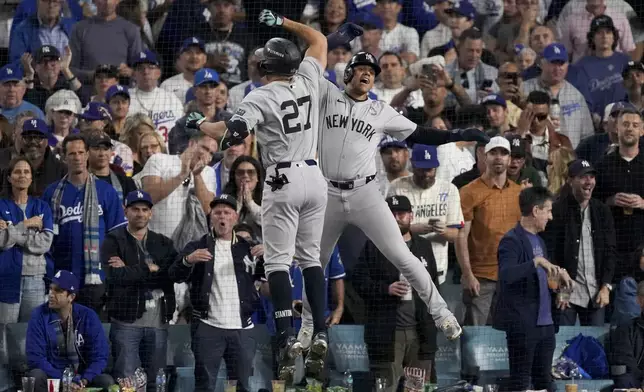 New York Yankees' Giancarlo Stanton, left, celebrates his two-run home with Juan Soto during the sixth inning in Game 1 of the baseball World Series against the Los Angeles Dodgers, Friday, Oct. 25, 2024, in Los Angeles. (AP Photo/Mark J. Terrill)