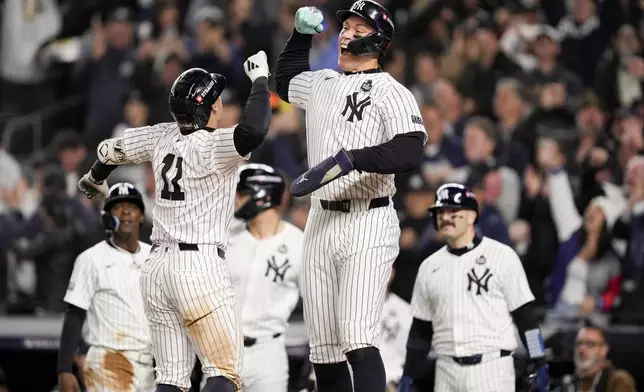 New York Yankees' Anthony Volpe celebrates his grand slam home run with Aaron Judge against the Los Angeles Dodgers during the third inning in Game 4 of the baseball World Series, Tuesday, Oct. 29, 2024, in New York. (AP Photo/Ashley Landis)