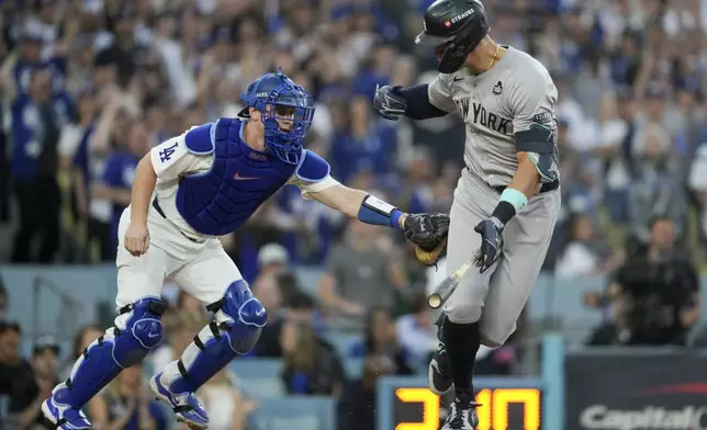 New York Yankees' Aaron Judge is tagged out by Los Angeles Dodgers catcher Will Smith during the third inning in Game 1 of the baseball World Series, Friday, Oct. 25, 2024, in Los Angeles. (AP Photo/Ashley Landis)