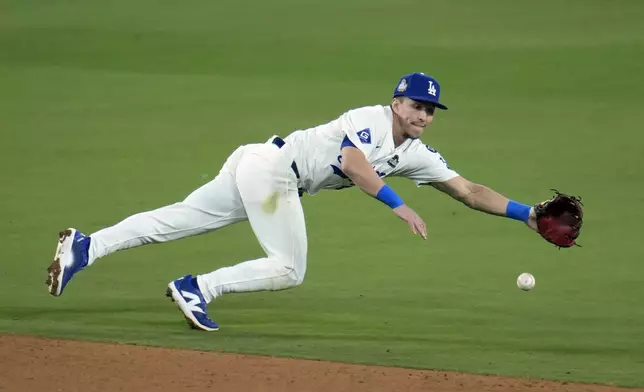 Los Angeles Dodgers shortstop Tommy Edman dives for a single by New York Yankees' Austin Wells during the sixth inning in Game 1 of the baseball World Series, Friday, Oct. 25, 2024, in Los Angeles. (AP Photo/Julio Cortez)