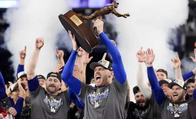 Los Angeles Dodgers' Freddie Freeman celebrates with the MVP trophy after their win against the New York Yankees in Game 5 to win the baseball World Series, Thursday, Oct. 31, 2024, in New York. (AP Photo/Ashley Landis)