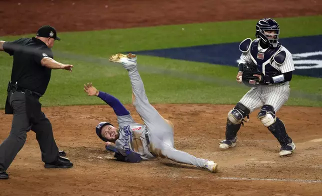 Los Angeles Dodgers' Gavin Lux (9) is safe at home plate as New York Yankees catcher Jose Trevino looks to the infield during the sixth inning in Game 3 of the baseball World Series, Monday, Oct. 28, 2024, in New York. (AP Photo/Seth Wenig)