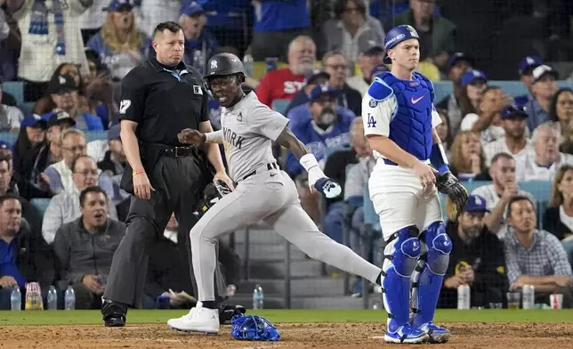 New York Yankees' Jazz Chisholm Jr. scores past Los Angeles Dodgers catcher Will Smith after a ground ball by Anthony Volpe during the 10th inning in Game 1 of the baseball World Series, Friday, Oct. 25, 2024, in Los Angeles. (AP Photo/Mark J. Terrill)