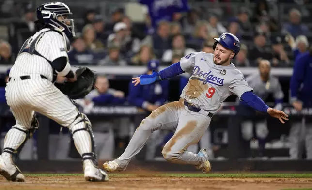 Los Angeles Dodgers' Gavin Lux (9) scores as New York Yankees catcher Jose Trevino waits for the throw during the sixth inning in Game 3 of the baseball World Series, Monday, Oct. 28, 2024, in New York. (AP Photo/Godofredo A. Vásquez)