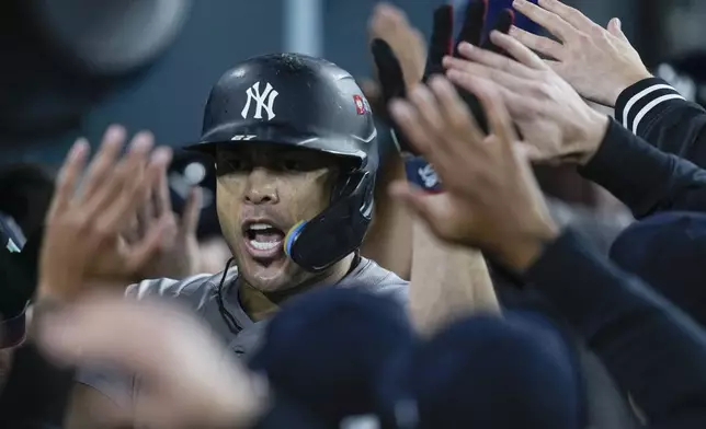 New York Yankees' Giancarlo Stanton celebrates in the dugout after his two-run home run against the Los Angeles Dodgers during the sixth inning in Game 1 of the baseball World Series, Friday, Oct. 25, 2024, in Los Angeles.(AP Photo/Ashley Landis)