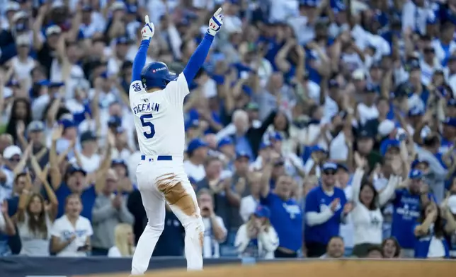 Los Angeles Dodgers' Freddie Freeman celebrates a triple against the New York Yankees during the first inning in Game 1 of the baseball World Series, Friday, Oct. 25, 2024, in Los Angeles. (AP Photo/Ashley Landis)