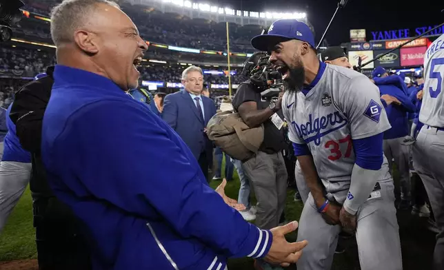 Los Angeles Dodgers manager Dave Roberts and Teoscar Hernández celebrate their win against the New York Yankees in Game 5 to win the baseball World Series, Wednesday, Oct. 30, 2024, in New York. (AP Photo/Ashley Landis)