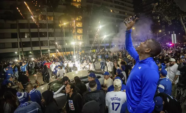 Fireworks go off as fans celebrate on the streets after the Los Angeles Dodgers defeated the New York Yankees to win the baseball World Series Wednesday, Oct. 30, 2024, in Los Angeles. (AP Photo/Ethan Swope)