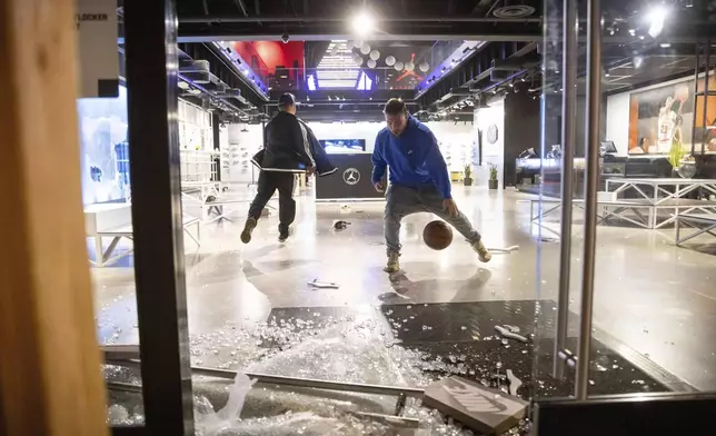 People are seen at a ransacked Nike store after the Los Angeles Dodgers defeated the New York Yankees to win the baseball World Series Wednesday, Oct. 30, 2024, in Los Angeles. (AP Photo/Ethan Swope)